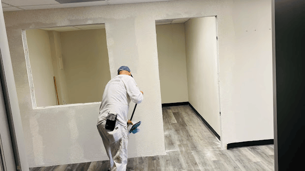 Professional painter finishing clean interior walls and floors