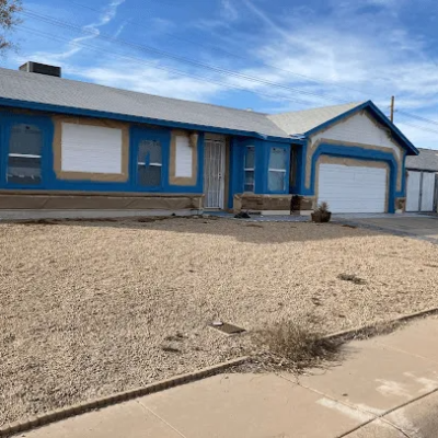 Residential exterior house painting in progress with blue trim preparation