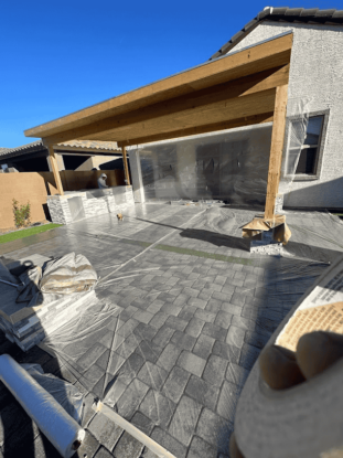 Patio build with wooden pergola and stone floor, protected by plastic sheets