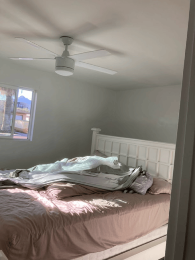 Bedroom with a bed and a ceiling fan, freshly painted