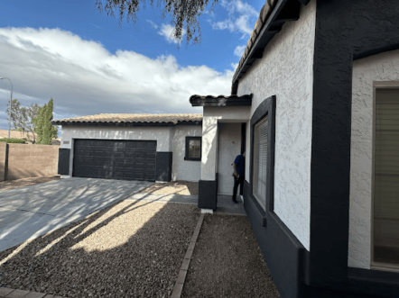 Exterior view of a modern home with a garage and stucco finish.