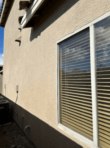 House exterior wall with window and blinds.