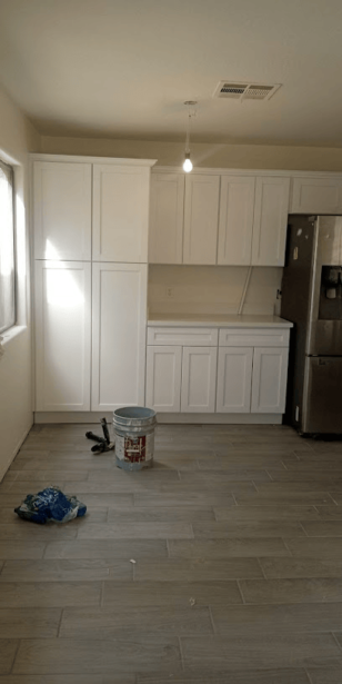 Newly painted white kitchen cabinets and clean floor