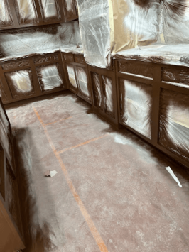 Kitchen cabinets covered for painting preparation.