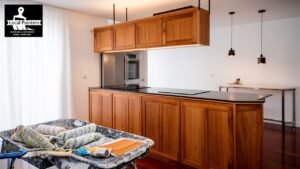 Painting supplies in front of a modern kitchen with wooden cabinets